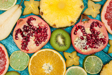 Colorful fruit slices on blue wood surface