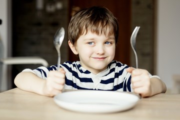 Happy little boy waiting for dinner.