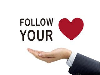 follow your heart words holding by businessman's hand