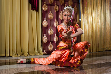 White woman is dancing in traditional indian dress