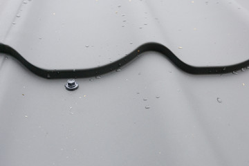 Metal tile roof with screw close-up