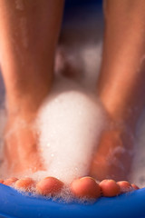 Female feet in soap bath