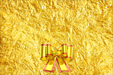 Shiny yellow leaf gold and  ribbon on Shiny foil texture backgro