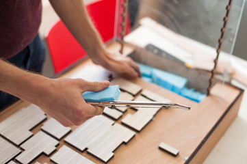 Student hands making architectural model in university studio