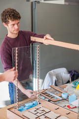 University architecture student building model in studio