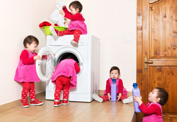 Smiling cute little child using washing machine at home