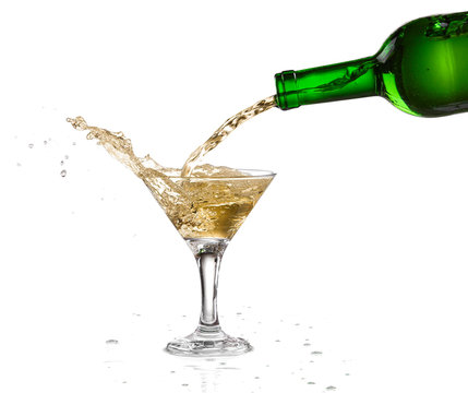 White wine pouring from the bottle intro the glass