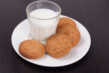 glass of milk and oat cookies on a plate