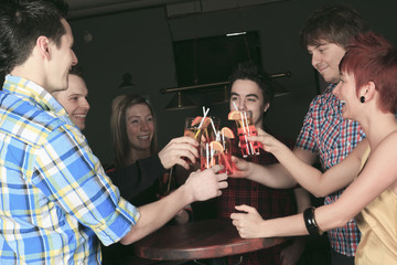 A group of friends drink on hand have some fun