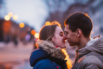 Portrait of young beautiful couple kissing in rain