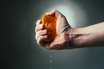 man dramatic squeezes orange. Conceptis tired from work.