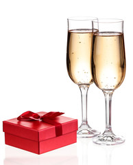 Glasses of champagne with gift box isolated on white