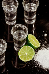 Tequila with lime on black background