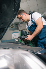 Professional car mechanic working in auto repair service