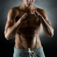 Fototapeta na wymiar young man on fighting stand over black background