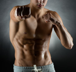 Fototapeta premium young man on fighting stand over black background