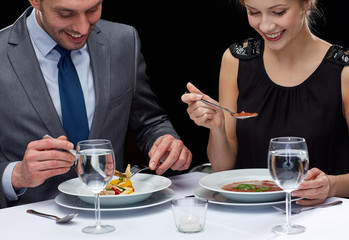 close up of couple eating at restaurant