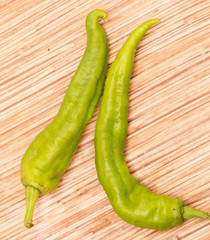 green hot peppers on a wooden background