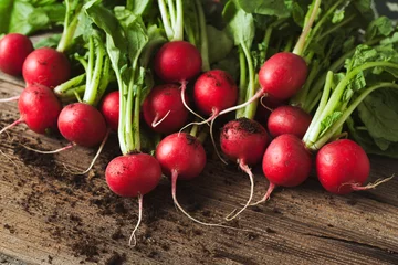 Fotobehang Bunch of healthy ripe radishes on rustic wooden background © GreenArt Photography