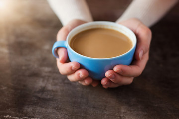 Unrecognizable woman holding a cup of coffee in her hands