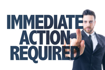 Business man pointing the text: Immediate Action Required