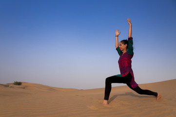 Obraz premium Young female practising yoga pose Warior or Virabhadrasana