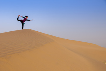 Young female practising yoga pose King Dancer or Natarajasana