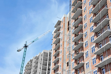 Obraz na płótnie Canvas Crane and building construction site against blue sky