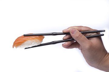hand holding chopsticks eating sushi om white background