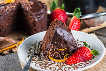 serving decorated dark chocolate cake on wooden table
