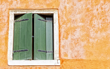 Half-closed window in a mediterranean alley