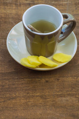 Obraz na płótnie Canvas Sliced ginger and ginger tea on a wooden table.