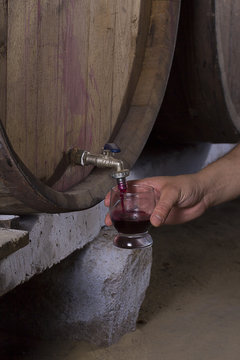Someone pours wine from a barrel