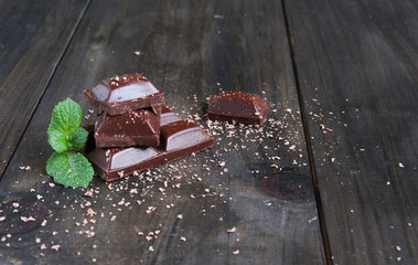 pieces of chocolate with mint lying on a wooden