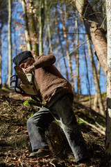 Senior man with chainsaw in a forest