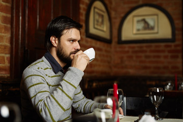 Young man drinking coffee in a restaurant