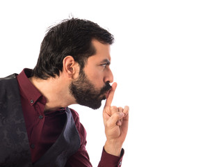 Man wearing waistcoat making silence gesture