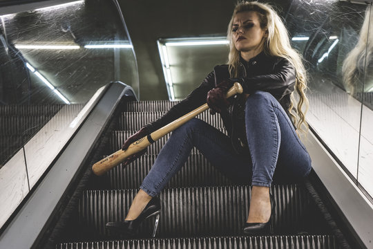 Street, Urban beautiful blonde with a baseball bat in escalators