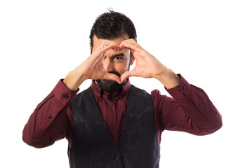 Man wearing waistcoat making a heart with his hands