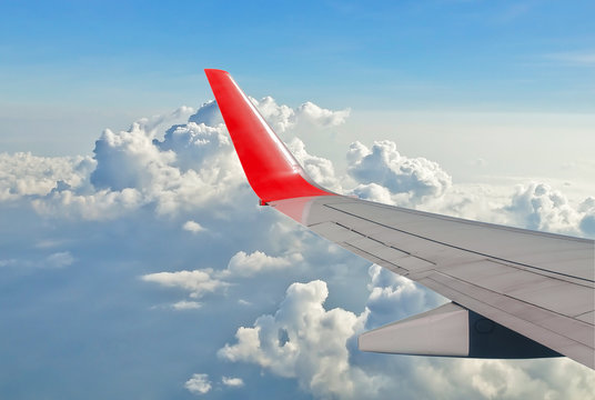 wing of an airplane flying above the clouds, view from the airpl