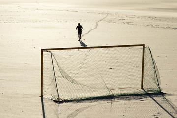 runner man and goal soccer on the beach in Galicia Spain