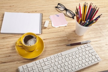 Notebook. Office table with coffee cup, supplies and copy space
