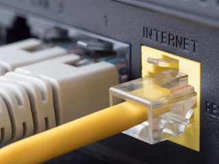 Network cables connected to a router or modem - obrazy, fototapety, plakaty