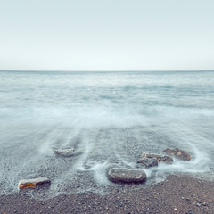Minimalist misty seascape with rocks at long exposure
