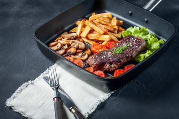 Fried steak with fries .