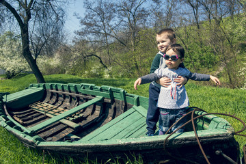 Little girl with brother having fun in an old boat