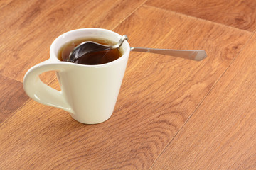 Black tea in a white cup and spoon