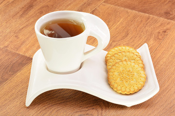 Black tea in a white mug and cookies