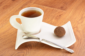 Black tea in a white mug and cake