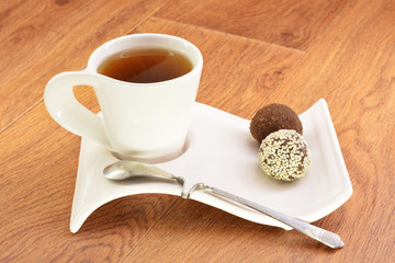 Black tea in a white mug and cake